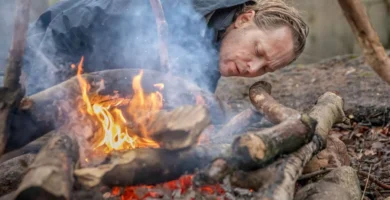 Persona encendiendo fuego en la naturaleza utilizando técnicas de supervivencia